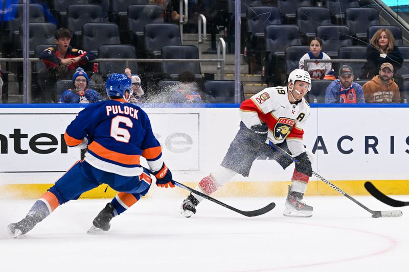 Oct 26, 2024; Elmont, New York, USA;  Florida Panthers left wing Matthew Tkachuk (19) looks for a pass while defended by New York Islanders defenseman Ryan Pulock (6) during the first period at UBS Arena. Mandatory Credit: Dennis Schneidler-Imagn Images