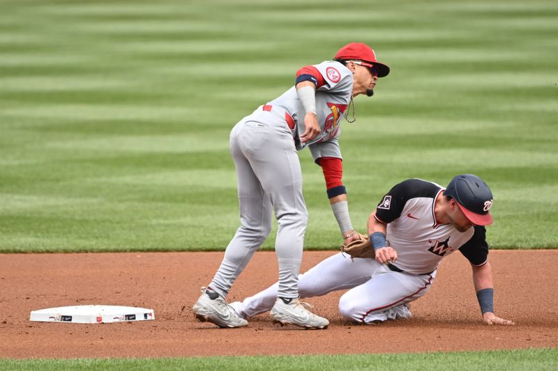 Jul 7, 2024; Washington, District of Columbia, USA; St. Louis Cardinals shortstop Masyn Winn (0) tags out Washington Nationals right fielder Lane Thomas (28) at second base during the first inning at Nationals Park. Mandatory Credit: Rafael Suanes-USA TODAY Sports