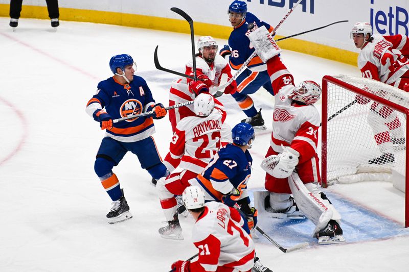 Nov 25, 2024; Elmont, New York, USA;  Detroit Red Wings goaltender Alex Lyon (34) makes a blocker save against the New York Islanders during the first period at UBS Arena. Mandatory Credit: Dennis Schneidler-Imagn Images