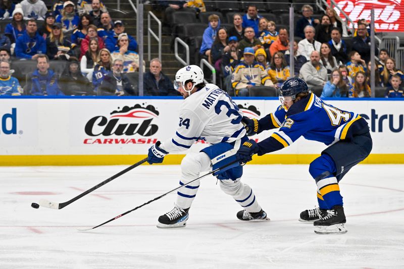 Feb 19, 2024; St. Louis, Missouri, USA;  Toronto Maple Leafs center Auston Matthews (34) shoots as St. Louis Blues right wing Kasperi Kapanen (42) defends during the first period at Enterprise Center. Mandatory Credit: Jeff Curry-USA TODAY Sports