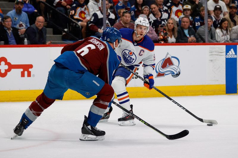 Apr 11, 2023; Denver, Colorado, USA; Edmonton Oilers center Connor McDavid (97) controls the puck as Colorado Avalanche defenseman Erik Johnson (6) defends in the first period at Ball Arena. Mandatory Credit: Isaiah J. Downing-USA TODAY Sports