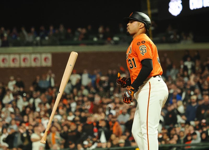 Sep 8, 2023; San Francisco, California, USA; San Francisco Giants left fielder LaMonte Wade Jr. (31) tosses his bat after earning in a walk with bases loaded to send in a run against the Colorado Rockies during the eighth inning at Oracle Park. Mandatory Credit: Kelley L Cox-USA TODAY Sports