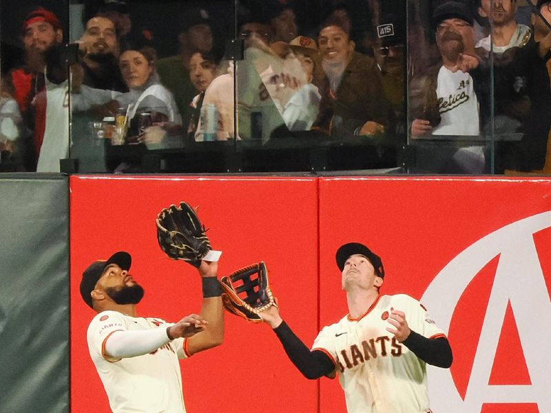 Jul 31, 2024; San Francisco, California, USA; San Francisco Giants center fielder Heliot Ramos (17) catches the ball next to right fielder Mike Yastrzemski (5) during the eighth inning against the Oakland Athletics at Oracle Park. Mandatory Credit: Kelley L Cox-USA TODAY Sports