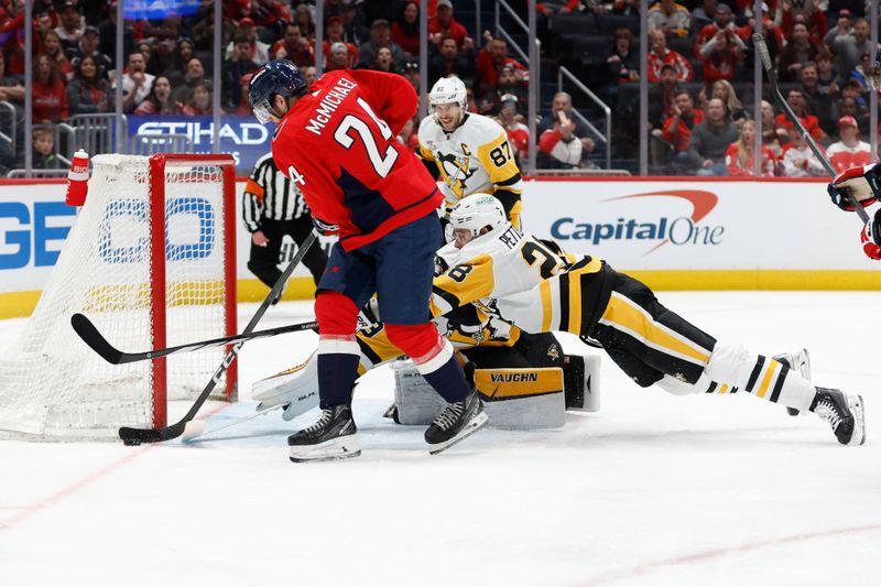 Apr 4, 2024; Washington, District of Columbia, USA; Washington Capitals center Connor McMichael (24) attempts to shoot the puck on Pittsburgh Penguins goaltender Alex Nedeljkovic (39) as Penguins defenseman Marcus Pettersson (28) defends in the first period at Capital One Arena. Mandatory Credit: Geoff Burke-USA TODAY Sports