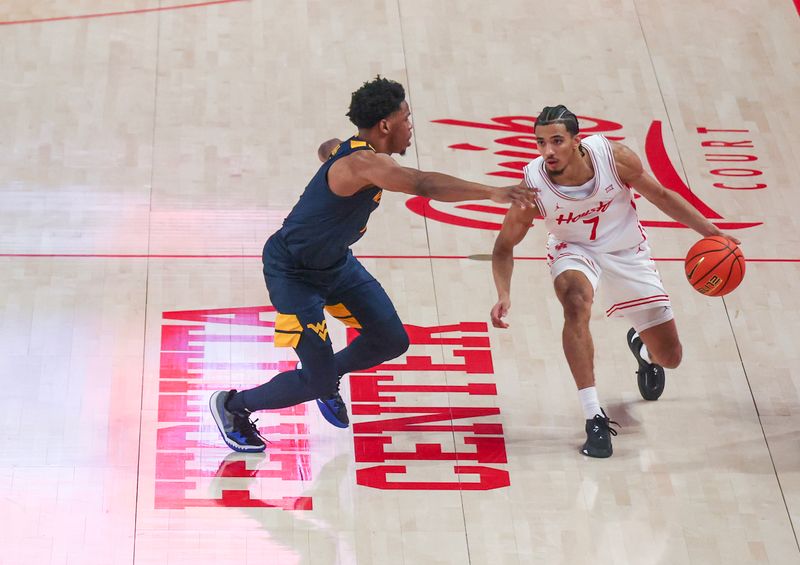 Jan 15, 2025; Houston, Texas, USA; Houston Cougars guard Milos Uzan (7) dribbles against West Virginia Mountaineers guard Joseph Yesufu (1) in the second half at Fertitta Center. Mandatory Credit: Thomas Shea-Imagn Images