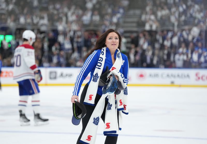 Oct 11, 2023; Toronto, Ontario, CAN; A member of the Toronto Maple Leafs ice crew picks up the hats and scarfs off the ice after Toronto Maple Leafs center Auston Matthews (34) (not pictured) scored his third goal of the game against the Montreal Canadiens during the third period at Scotiabank Arena. Mandatory Credit: Nick Turchiaro-USA TODAY Sports