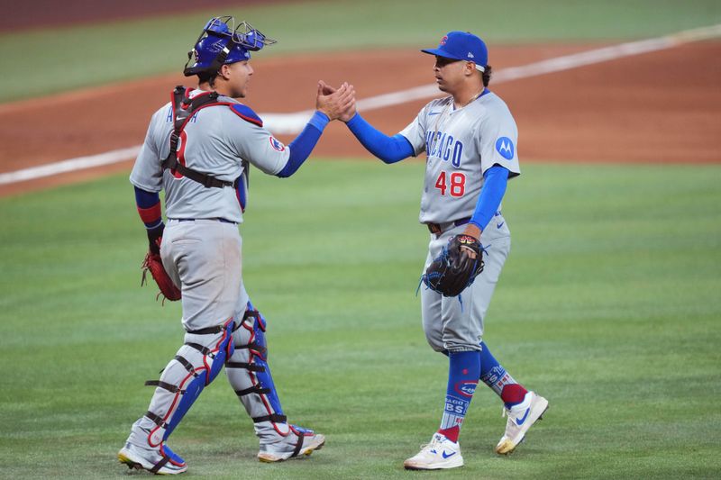 May 21, 2025; Miami, Florida, USA;  Chicago Cubs pitcher Daniel Palencia (48) and catcher Miguel Amaya (9) celebrate a victory against the Miami Marlins at loanDepot Park. Mandatory Credit: Jim Rassol-Imagn Images