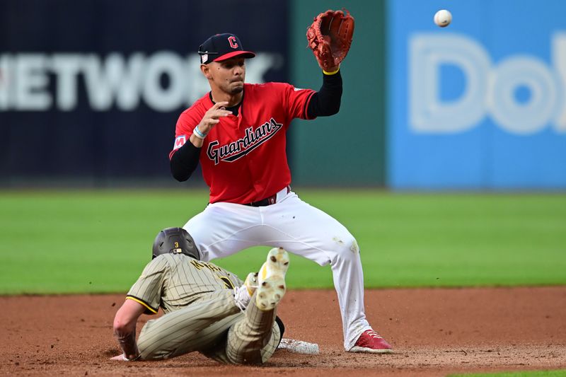 Jul 20, 2024; Cleveland, Ohio, USA; San Diego Padres center fielder Jackson Merrill (3) dives back to second as Cleveland Guardians second baseman Andres Gimenez (0) waits for the pickoff throw during the fourth inning at Progressive Field. Mandatory Credit: Ken Blaze-USA TODAY Sports