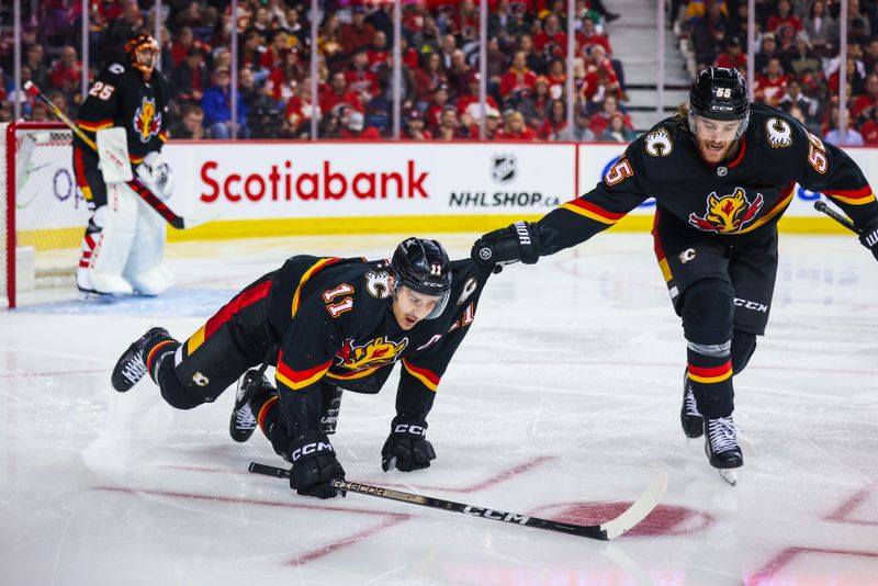 Jan 23, 2024; Calgary, Alberta, CAN; Calgary Flames defenseman Noah Hanifin (55) helps center Mikael Backlund (11) off the ice after he lost his skate blade during the third period against the St. Louis Blues at Scotiabank Saddledome. Mandatory Credit: Sergei Belski-USA TODAY Sports