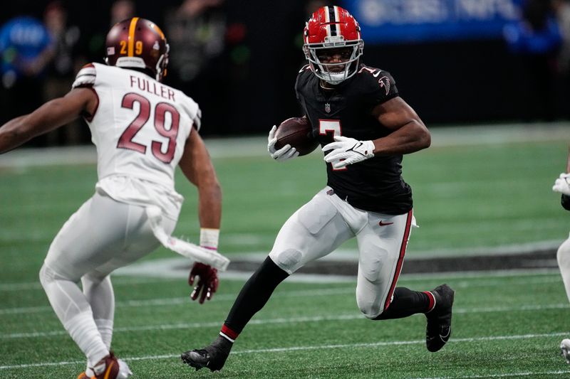 Atlanta Falcons running back Bijan Robinson (7) runs near Washington Commanders cornerback Kendall Fuller (29) during the first half of an NFL football game, Sunday, Oct. 15, 2023, in Atlanta. (AP Photo/John Bazemore)