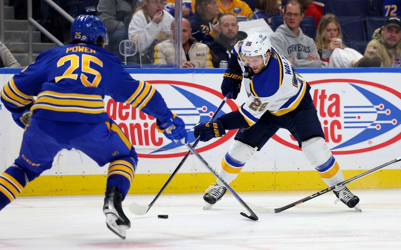 Feb 10, 2024; Buffalo, New York, USA;  Buffalo Sabres defenseman Owen Power (25) tries to block the puck from St. Louis Blues left wing Nathan Walker (26) during the third period at KeyBank Center. Mandatory Credit: Timothy T. Ludwig-USA TODAY Sports