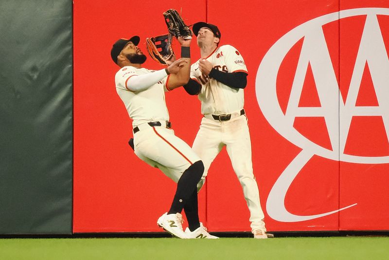 Jul 31, 2024; San Francisco, California, USA; San Francisco Giants center fielder Heliot Ramos (17) catches the ball next to right fielder Mike Yastrzemski (5) during the eighth inning against the Oakland Athletics at Oracle Park. Mandatory Credit: Kelley L Cox-USA TODAY Sports