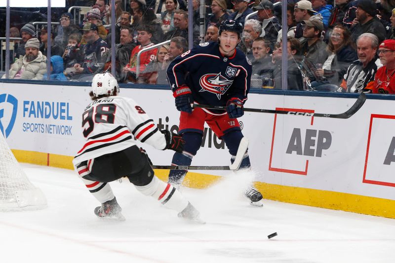 Feb 4, 2026; Columbus, Ohio, USA; Columbus Blue Jackets defenseman Zach Werenski (8) chips the puck past Chicago Blackhawks center Connor Bedard (98) during the first period at Nationwide Arena. Mandatory Credit: Russell LaBounty-Imagn Images