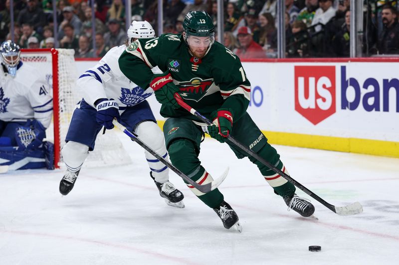 Mar 15, 2026; Saint Paul, Minnesota, USA; Minnesota Wild center Yakov Trenin (13) and Toronto Maple Leafs defenseman Simon Benoit (2) compete for the puck during the second period at Grand Casino Arena. Mandatory Credit: Matt Krohn-Imagn Images