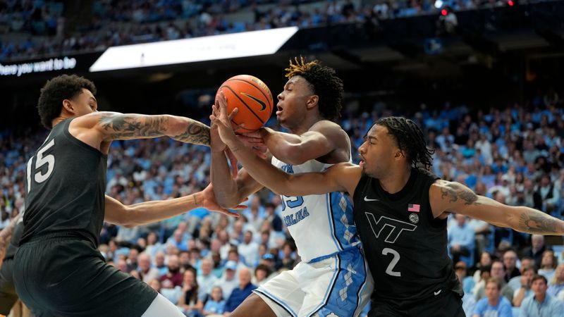 Feb 17, 2024; Chapel Hill, North Carolina, USA; North Carolina Tar Heels forward Harrison Ingram (55) with the ball as Virginia Tech Hokies center Lynn Kidd (15) and guard MJ Collins (2) defend in the second half at Dean E. Smith Center. Mandatory Credit: Bob Donnan-USA TODAY Sports