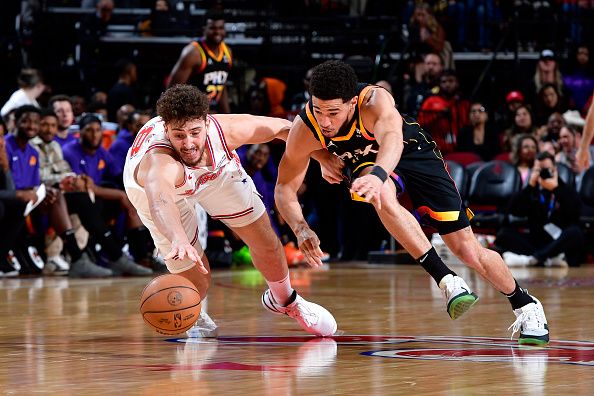 HOUSTON, TX - DECEMBER 27:   Alperen Sengun #28 of the Houston Rockets and Devin Booker #1 of the Phoenix Suns dives after a loose ball on December 27, 2023 at the Toyota Center in Houston, Texas. NOTE TO USER: User expressly acknowledges and agrees that, by downloading and or using this photograph, User is consenting to the terms and conditions of the Getty Images License Agreement. Mandatory Copyright Notice: Copyright 2023 NBAE (Photo by Logan Riely/NBAE via Getty Images)