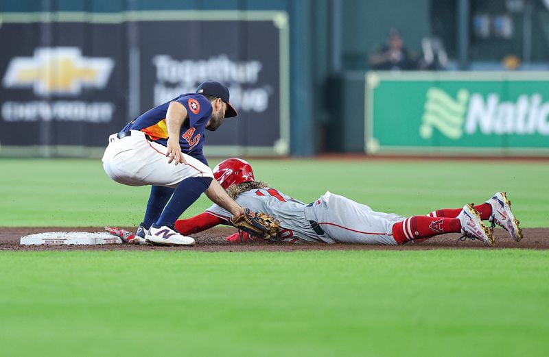 Sep 22, 2024; Houston, Texas, USA; Los Angeles Angels second baseman Jack Lopez (10) is tagged out by Houston Astros second baseman Jose Altuve (27) on a stolen base attempt during the third inning at Minute Maid Park. Mandatory Credit: Troy Taormina-Imagn Images