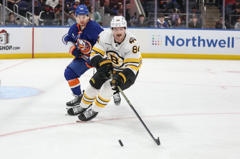 Nov 26, 2025; Elmont, New York, USA; New York Islanders right wing Max Shabanov (49) and Boston Bruins left wing Tanner Jeannot (84) chase after the puck in the first period at UBS Arena. Mandatory Credit: Wendell Cruz-Imagn Images