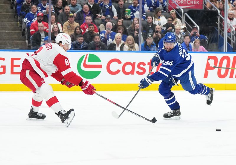 Apr 13, 2024; Toronto, Ontario, CAN; Toronto Maple Leafs center Auston Matthews (34) fans on a shot as Detroit Red Wings defenseman Ben Chiarot (8) tries to defend during the third period at Scotiabank Arena. Mandatory Credit: Nick Turchiaro-USA TODAY Sports