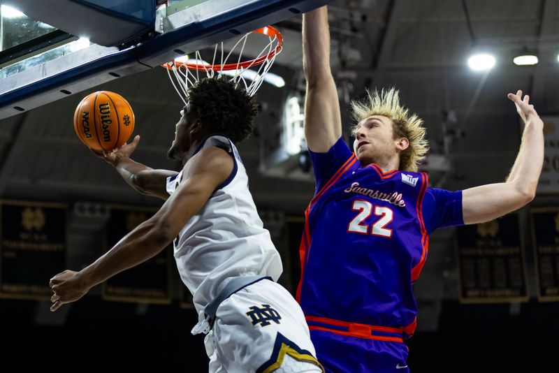 Dec 13, 2025; South Bend, Indiana, USA; Notre Dame Fighting Irish guard Jalen Haralson (10) drives past Evansville Purple Aces forward Connor Turnbull (22) during the first half at Purcell Pavilion at the Joyce Center. Mandatory Credit: Michael Caterina-Imagn Images