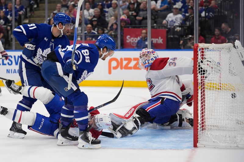 Sep 27, 2025; Toronto, Ontario, CAN; Toronto Maple Leafs forward William Nylander (88) scores against the Montreal Canadiens goaltender Kaapo Kahkonen (34) as Montreal Canadiens defenseman Marc Del Gaizo (37) and Toronto Maple Leafs forward John Tavares (91) look on during the third period at Scotiabank Arena. Mandatory Credit: John E. Sokolowski-Imagn Images