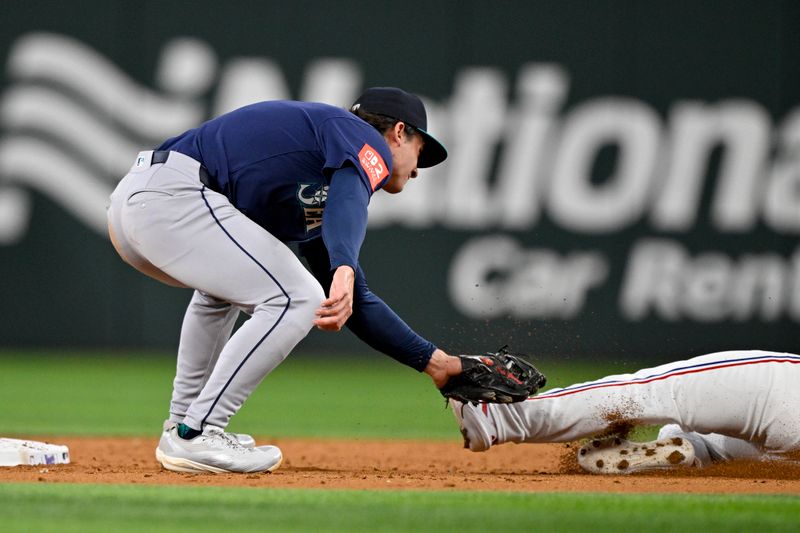 Jun 28, 2025; Arlington, Texas, USA; Seattle Mariners second baseman Cole Young (2) tags out Texas Rangers left fielder Alejandro Osuna (19) on a steal attempt during the third inning at Globe Life Field. Mandatory Credit: Jerome Miron-Imagn Images
