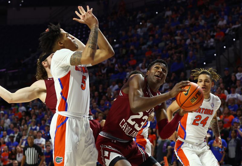 Jan 25, 2023; Gainesville, Florida, USA; South Carolina Gamecocks forward Gregory Jackson II (23) shoots over Florida Gators guard Will Richard (5) and guard Riley Kugel (24) during the first half at Exactech Arena at the Stephen C. O'Connell Center. Mandatory Credit: Kim Klement-USA TODAY Sports