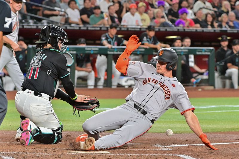 Sep 23, 2024; Phoenix, Arizona, USA;  San Francisco Giants third baseman Matt Chapman (26) slides home with an inside the park home run as Diamondbacks catcher Jose Herrera (11) defends in the third inning at Chase Field. Mandatory Credit: Matt Kartozian-Imagn Images