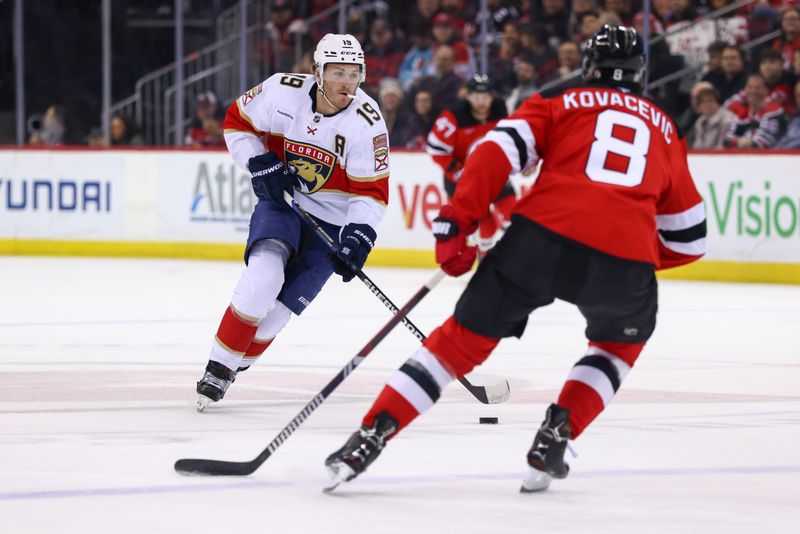 Jan 14, 2025; Newark, New Jersey, USA; Florida Panthers left wing Matthew Tkachuk (19) skates with the puck while being defended by New Jersey Devils defenseman Johnathan Kovacevic (8) during the first period at Prudential Center. Mandatory Credit: Ed Mulholland-Imagn Images