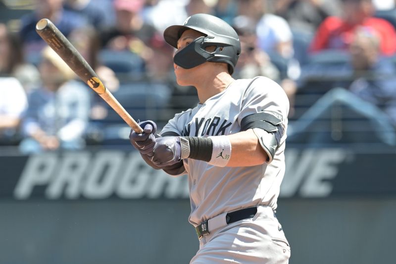 Apr 23, 2025; Cleveland, Ohio, USA; New York Yankees right fielder Aaron Judge (99) hits an RBI triple during the first inning against the Cleveland Guardians at Progressive Field. Mandatory Credit: Ken Blaze-Imagn Images