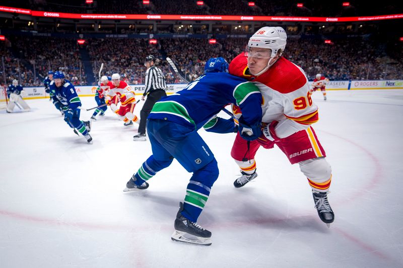 Apr 16, 2024; Vancouver, British Columbia, CAN; Vancouver Canucks defenseman Ian Cole (82) checks Calgary Flames forward Andrei Kuzmenko (96) in the second period at Rogers Arena. Mandatory Credit: Bob Frid-USA TODAY Sports