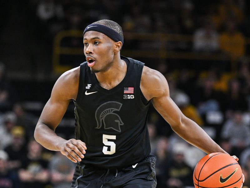 Mar 6, 2025; Iowa City, Iowa, USA; Michigan State Spartans guard Tre Holloman (5) controls the ball against the Iowa Hawkeyes during the first half at Carver-Hawkeye Arena. Mandatory Credit: Jeffrey Becker-Imagn Images