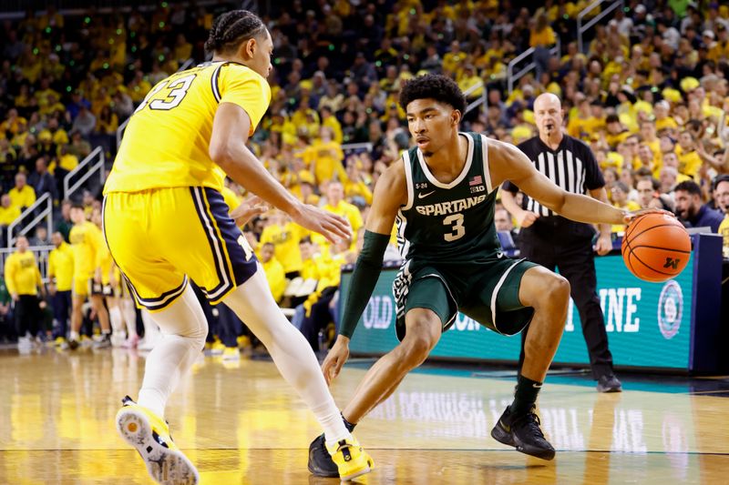 Feb 18, 2023; Ann Arbor, Michigan, USA;  Michigan State Spartans guard Jaden Akins (3) dribbles the ball against Michigan Wolverines guard Jett Howard (13) in the second half at Crisler Center. Mandatory Credit: Rick Osentoski-USA TODAY Sports