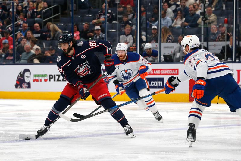 Oct 28, 2024; Columbus, Ohio, USA; Columbus Blue Jackets right wing Kirill Marchenko (86) passes the puck as Edmonton Oilers defenseman Brett Kulak (27) defends during the second period at Nationwide Arena. Mandatory Credit: Russell LaBounty-Imagn Images