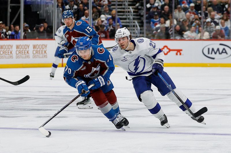 Nov 4, 2025; Denver, Colorado, USA; Colorado Avalanche defenseman Sam Malinski (70) controls the puck ahead of Tampa Bay Lightning center Brayden Point (21) in the third period at Ball Arena. Mandatory Credit: Isaiah J. Downing-Imagn Images