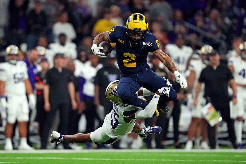 Jan 8, 2024; Houston, TX, USA; Michigan Wolverines running back Blake Corum (2) runs the ball against Washington Huskies cornerback Elijah Jackson (25) during the third quarter in the 2024 College Football Playoff national championship game at NRG Stadium. Mandatory Credit: Kirby Lee-USA TODAY Sports