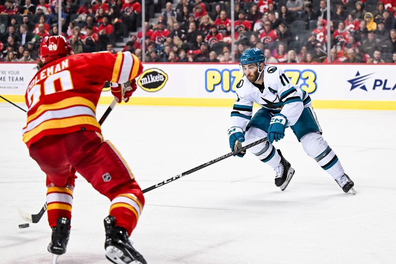 Feb 15, 2024; Calgary, Alberta, CAN; San Jose Sharks center Luke Kunin (11) skates against Calgary Flames center Blake Coleman (20) during the second period at Scotiabank Saddledome. Mandatory Credit: Brett Holmes-USA TODAY Sports