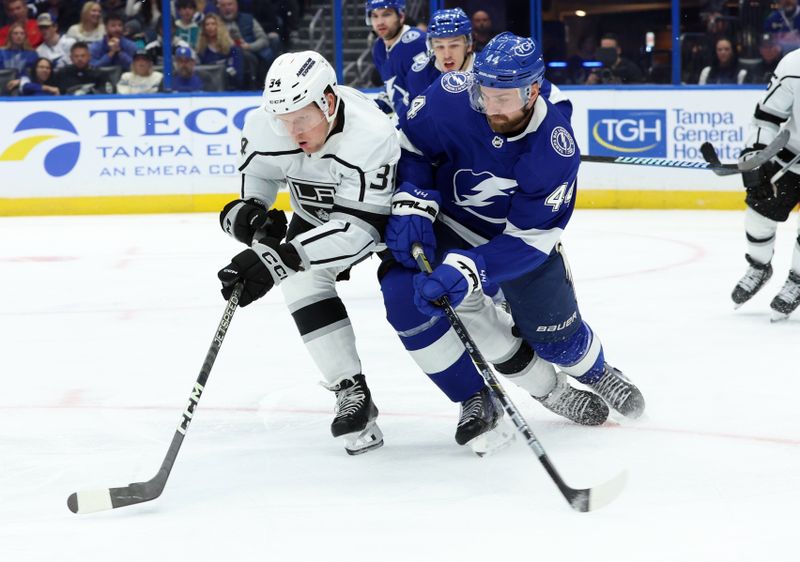 Jan 9, 2024; Tampa, Florida, USA; Los Angeles Kings right wing Arthur Kaliyev (34) and Tampa Bay Lightning defenseman Calvin de Haan (44) defend the puck during the second period at Amalie Arena. Mandatory Credit: Kim Klement Neitzel-USA TODAY Sports