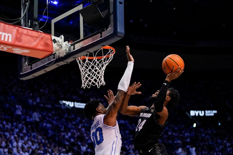 Feb 14, 2026; Provo, Utah, USA; Barrington Hargress (24) of the Colorado Buffaloes drives to the basket while being defended by BYU Cougars forward Kennard Davis Jr. (30) during the second half at the Marriott Center. Mandatory Credit: Aaron Baker-Imagn Images