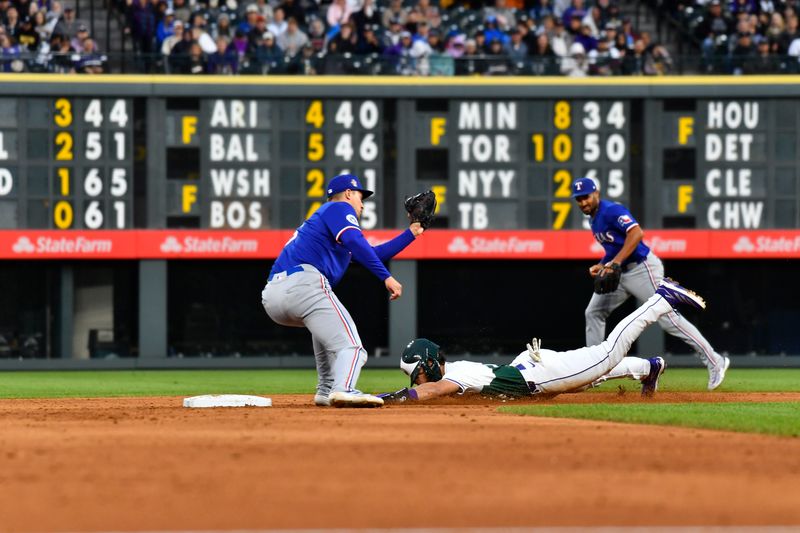 May 11, 2024; Denver, Colorado, USA; Texas Rangers shortstop Corey Seager (5) tags out Colorado Rockies shortstop Ezequiel Tovar (14) on a stolen base attempt in the fifth inning at Coors Field. Mandatory Credit: John Leyba-USA TODAY Sports