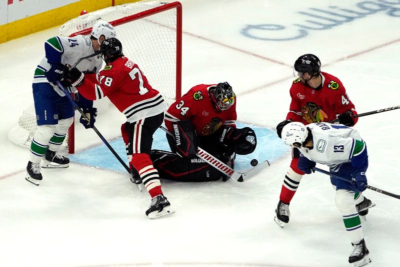 Oct 22, 2024; Chicago, Illinois, USA; Chicago Blackhawks goaltender Petr Mrazek (34) makes a save on Vancouver Canucks left wing Arshdeep Bains (13) during the second period at United Center. Mandatory Credit: David Banks-Imagn Images