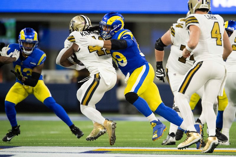 Los Angeles Rams defensive tackle Aaron Donald (99) tackles New Orleans Saints running back Alvin Kamara (41) during an NFL football game, Thursday, Dec. 21, 2023, in Inglewood, Calif. (AP Photo/Kyusung Gong)