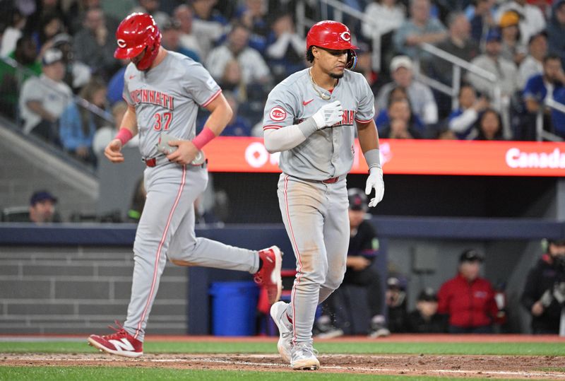 Aug 21, 2024; Toronto, Ontario, CAN;  Cincinnati Reds designated hitter Santiago Espinal (4) moves toward first base after drawing a bases loaded walk that score catcher Tyler Stephenson (37) in the fifth inning at Rogers Centre. Mandatory Credit: Dan Hamilton-USA TODAY Sports