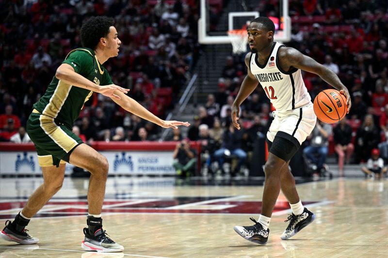 Feb 13, 2024; San Diego, California, USA; San Diego State Aztecs guard Darrion Trammell (12) dribbles the ball while defended by Colorado State Rams guard Jalen Lake (15) during the first half at Viejas Arena. Mandatory Credit: Orlando Ramirez-USA TODAY Sports