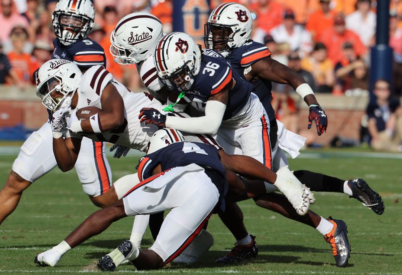 Oct 28, 2023; Auburn, Alabama, USA; Mississippi State Bulldogs running back Seth Davis (23) is tackled by Auburn Tigers cornerback D.J. James (4) and cornerback Jaylin Simpson (36) during the second quarter at Jordan-Hare Stadium. Mandatory Credit: John Reed-USA TODAY Sports