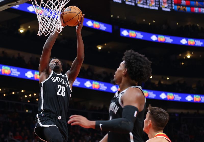 ATLANTA, GEORGIA - DECEMBER 06:  Dorian Finney-Smith #28 of the Brooklyn Nets dunks an alley-oop from Dennis Smith Jr. #4 against Bogdan Bogdanovic #13 of the Atlanta Hawks during the fourth quarter at State Farm Arena on December 06, 2023 in Atlanta, Georgia.  NOTE TO USER: User expressly acknowledges and agrees that, by downloading and/or using this photograph, user is consenting to the terms and conditions of the Getty Images License Agreement.  (Photo by Kevin C. Cox/Getty Images)