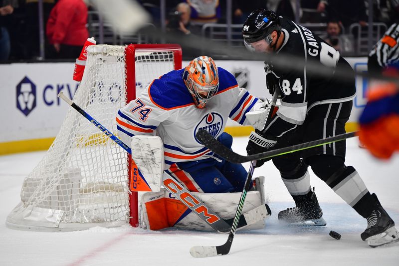 Dec 30, 2023; Los Angeles, California, USA; Edmonton Oilers goaltender Stuart Skinner (74) defends the goal against Los Angeles Kings defenseman Vladislav Gavrikov (84) during the overtime period at Crypto.com Arena. Mandatory Credit: Gary A. Vasquez-USA TODAY Sports