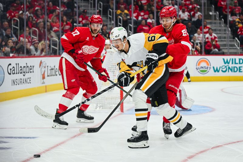 Oct 10, 2024; Detroit, Michigan, USA; Pittsburgh Penguins right wing Rickard Rakell (67) and Detroit Red Wings defenseman Moritz Seider (53) battle for the puck during the first period at Little Caesars Arena. Mandatory Credit: Tim Fuller-Imagn Images