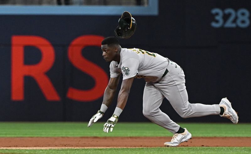 Aug 11, 2024; Toronto, Ontario, CAN; Oakland Athletics left field Daz Cameron (28) slides into second base with a double in the first inning against the Toronto Blue Jays at Rogers Centre. Mandatory Credit: Gerry Angus-USA TODAY Sports
