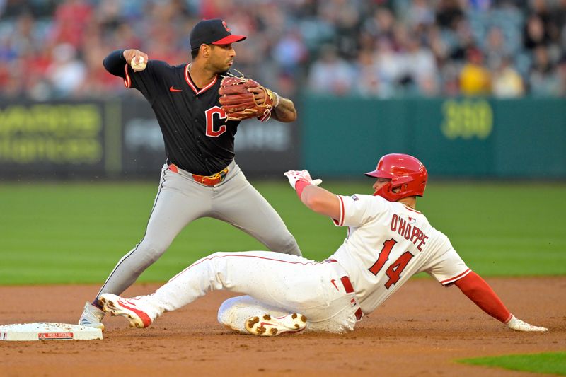 Apr 5, 2025; Anaheim, California, USA;  Cleveland Guardians shortstop Brayan Rocchio (4) throws to first as Los Angeles Angels catcher Logan O'Hoppe (14) is out at second in the second inning at Angel Stadium. Mandatory Credit: Jayne Kamin-Oncea-Imagn Images